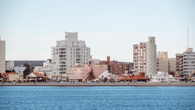 Explore a vibrant cityscape featuring modern architecture along a scenic waterfront, ideal for travel and urban imagery.